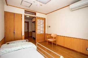 車椅子に座っている高齢女性と介助をする女性ヘルパー