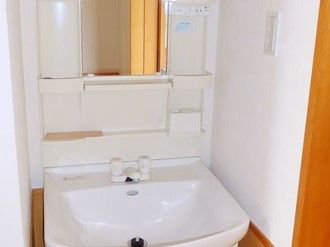 洗面台を写した写真。ホワイトを基調とした収納付きの洗面台