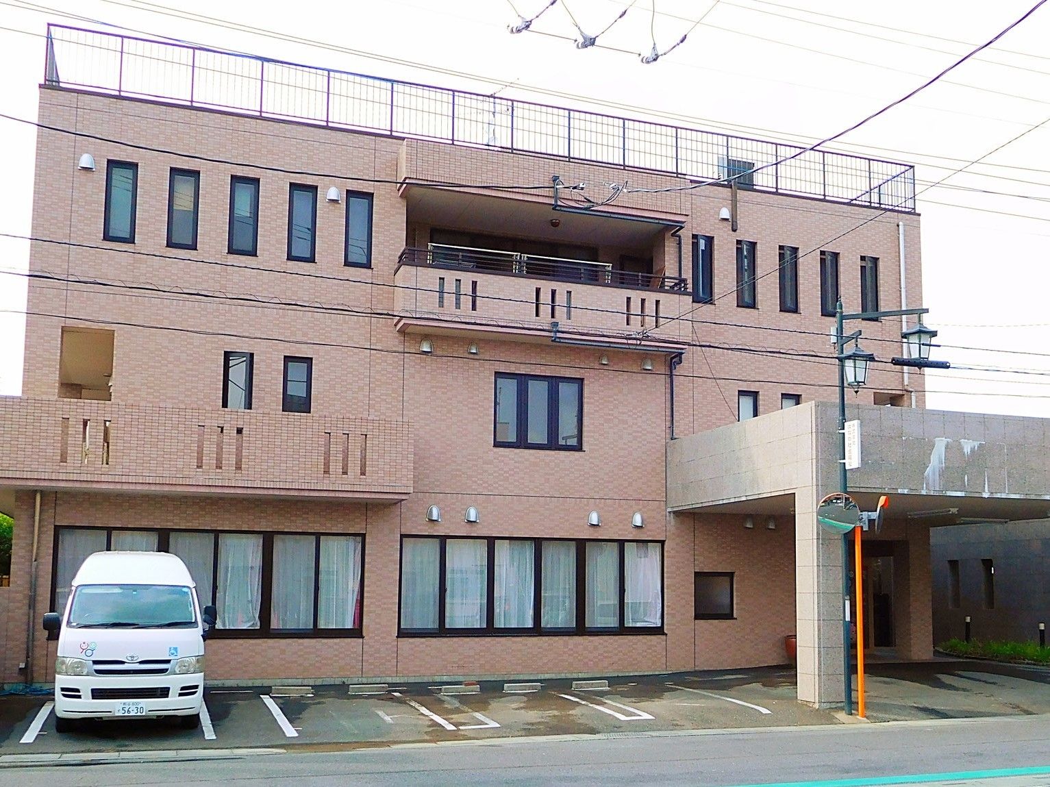 鉄骨造３階建ての建物。淡い色合いの建物が写っているのが分かる