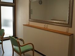 美容室には大きな鏡と胃どり色のいすが置かれている。