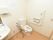 広々とした設計のトイレである。手すり横に緊急呼び出しボタンを完備。フットレス仕様の手洗い場も、備えつけられている。