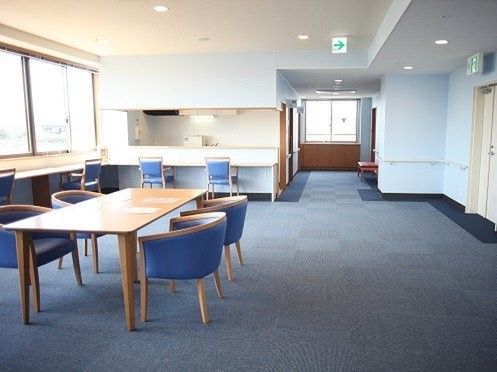 対面式のキッチンにカウンター式のテーブル、それとは別に長方形のテーブルがあり、座り心地のよさそうないすが並んでいる。