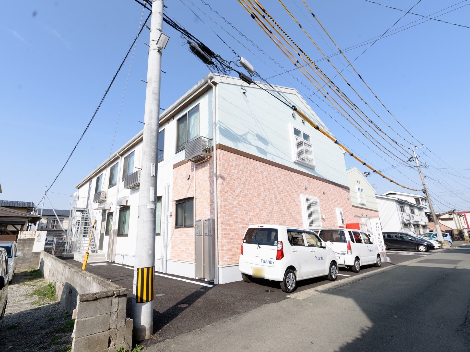 外観は三角屋根が付いた2階建ての建物。二つの建物をつなぐように玄関があり、玄関周りにはスロープもある。