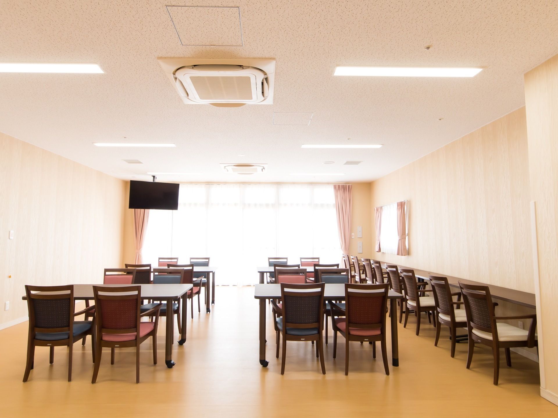 空調の付いた広いフロアがあり、ダイニングテーブルが並んでいる。壁際にはカウンター席も設けられている。