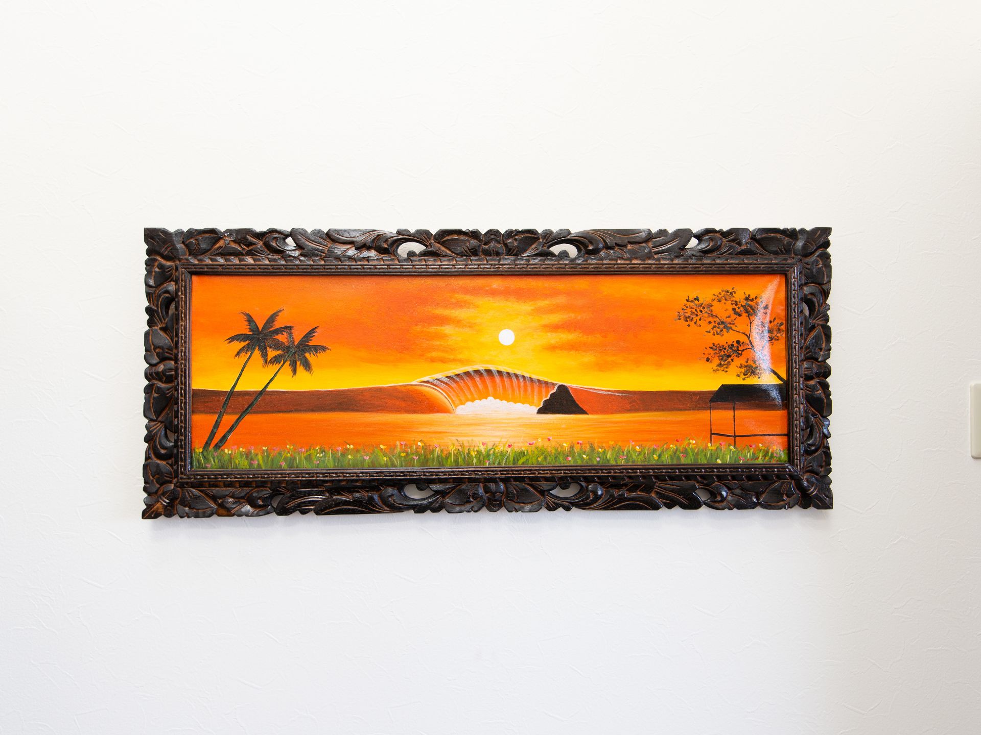 しっかりした木の額縁に夕焼けの絵画がエントランスに飾ってある。出入り口を高級な雰囲気を演出することができる。