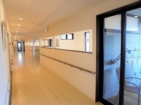 明るい廊下には手すりが付き安全に利用できる。余計なものが置かれていないシンプルな造り。
