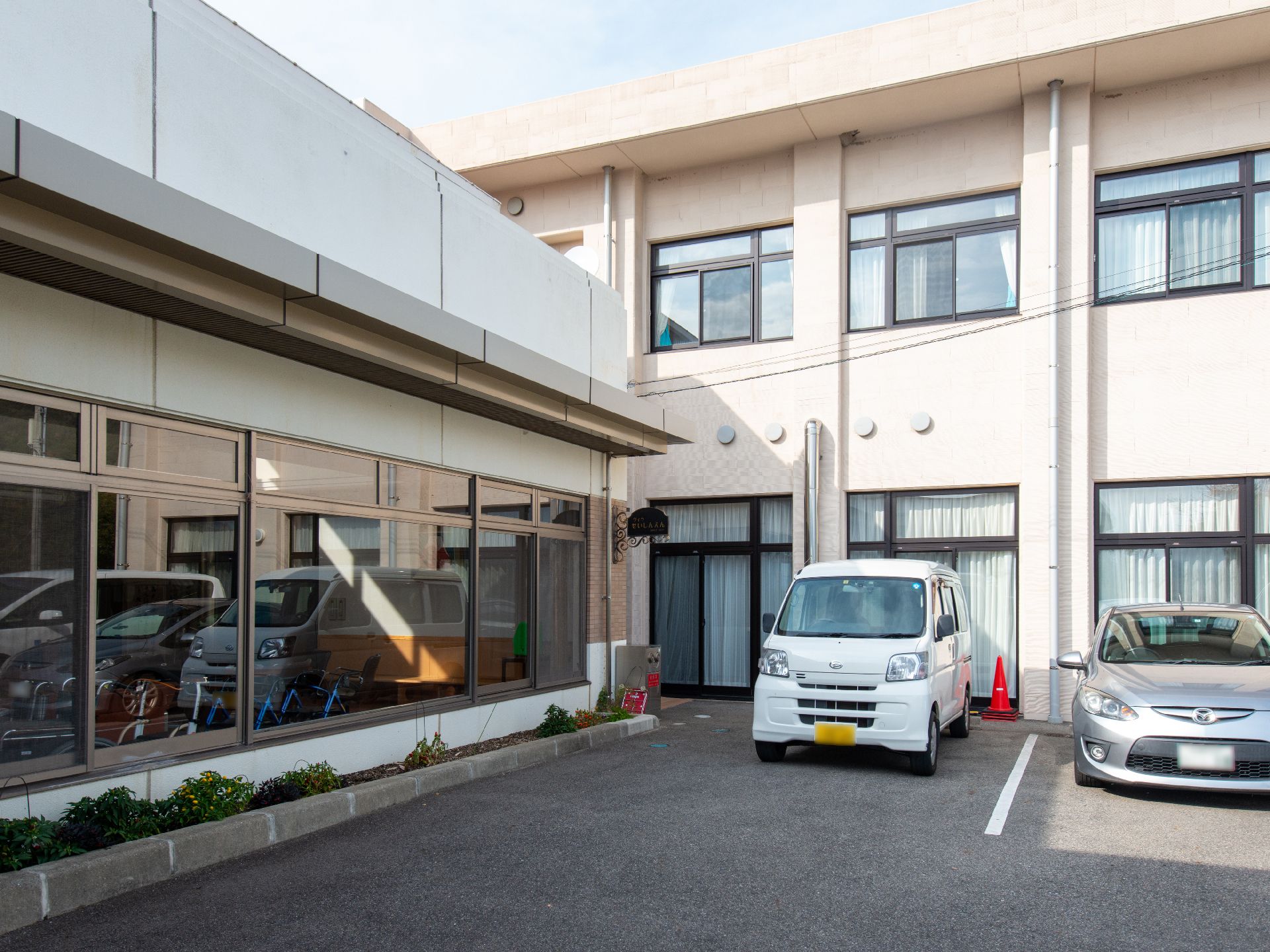 赤い車椅子に座った高齢女性と介助をする女性ヘルパー