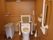濃い色のフローリングが敷かれた温水洗浄機能付きのトイレがある。壁や便座には手すりがかかっている。