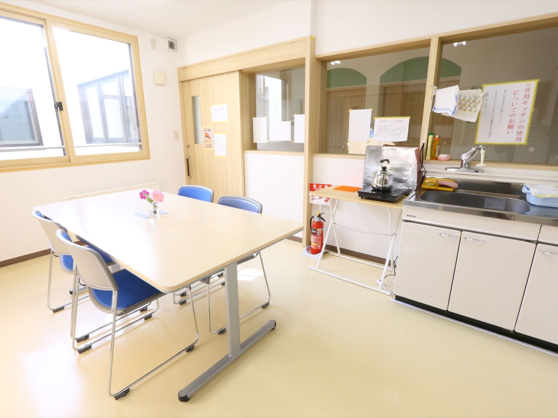 白の壁と天井に、明るいベージュの床である。窓枠は木目調となっている。IH式の卓上コンロとシンクが備えつけられている。