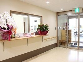 スタッフルームの受付には蘭などの花が飾られ華やか。玄関は自動ドアで段差もない。