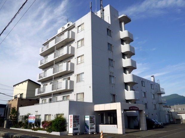 6階建ての建物はワイグレーで1階部分にある玄関わきには自動販売機が2台置かれている。