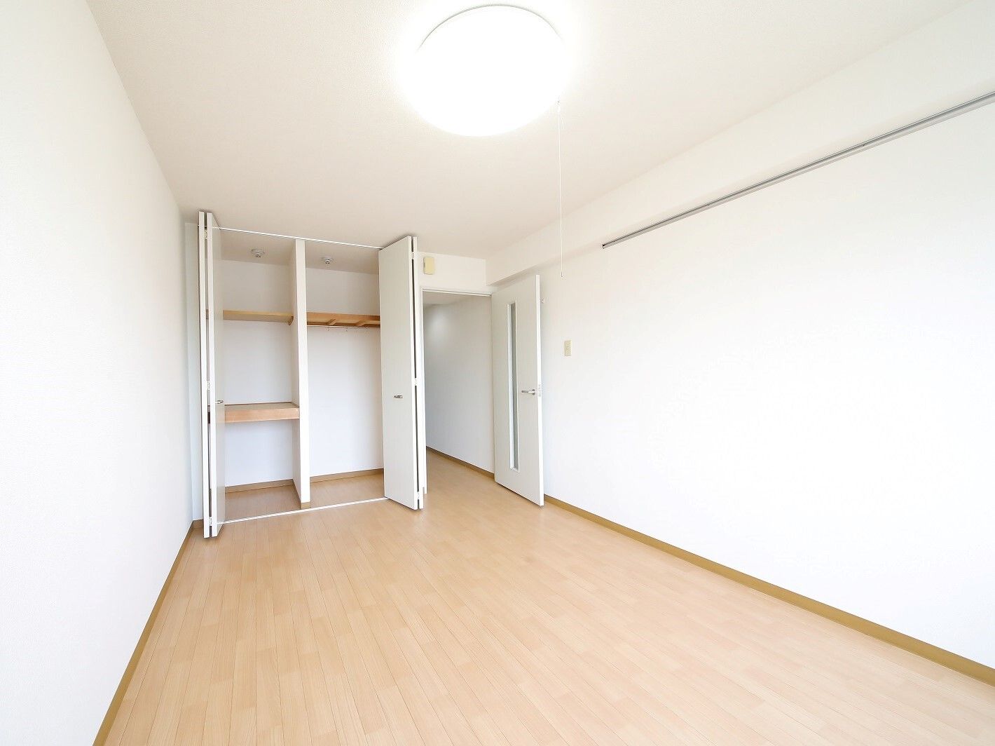 建物外観。グレーの6階建ての建物。1階部分には自動販売機がある。