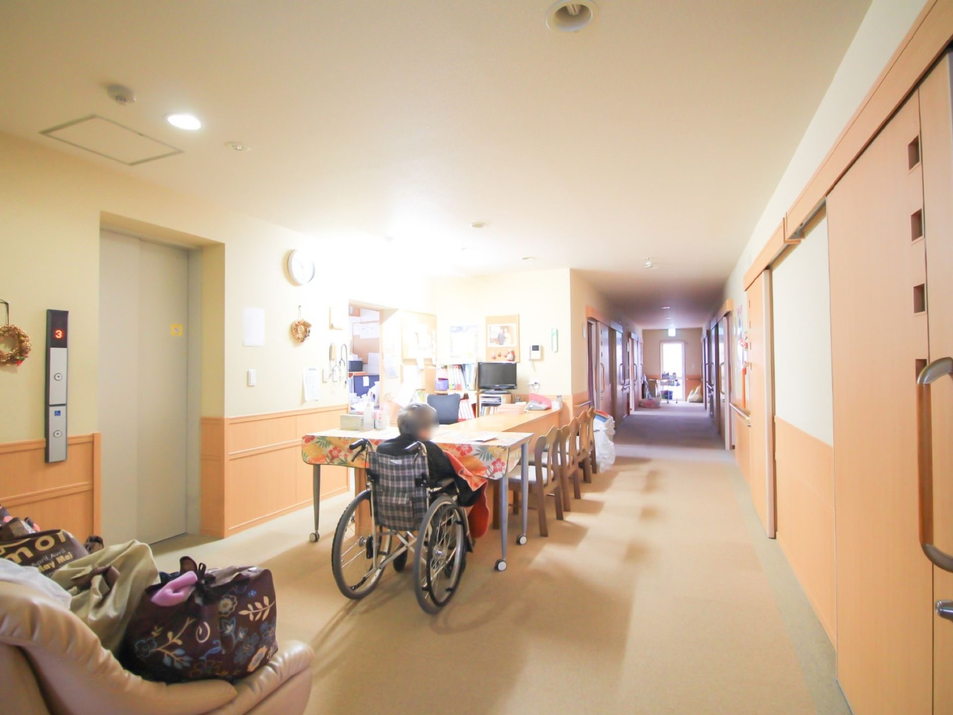 廊下の中央に事務室があり、隣にはエレベーターが設置されている。壁には随所に手すりがあり、横幅が広く行き来しやすい。