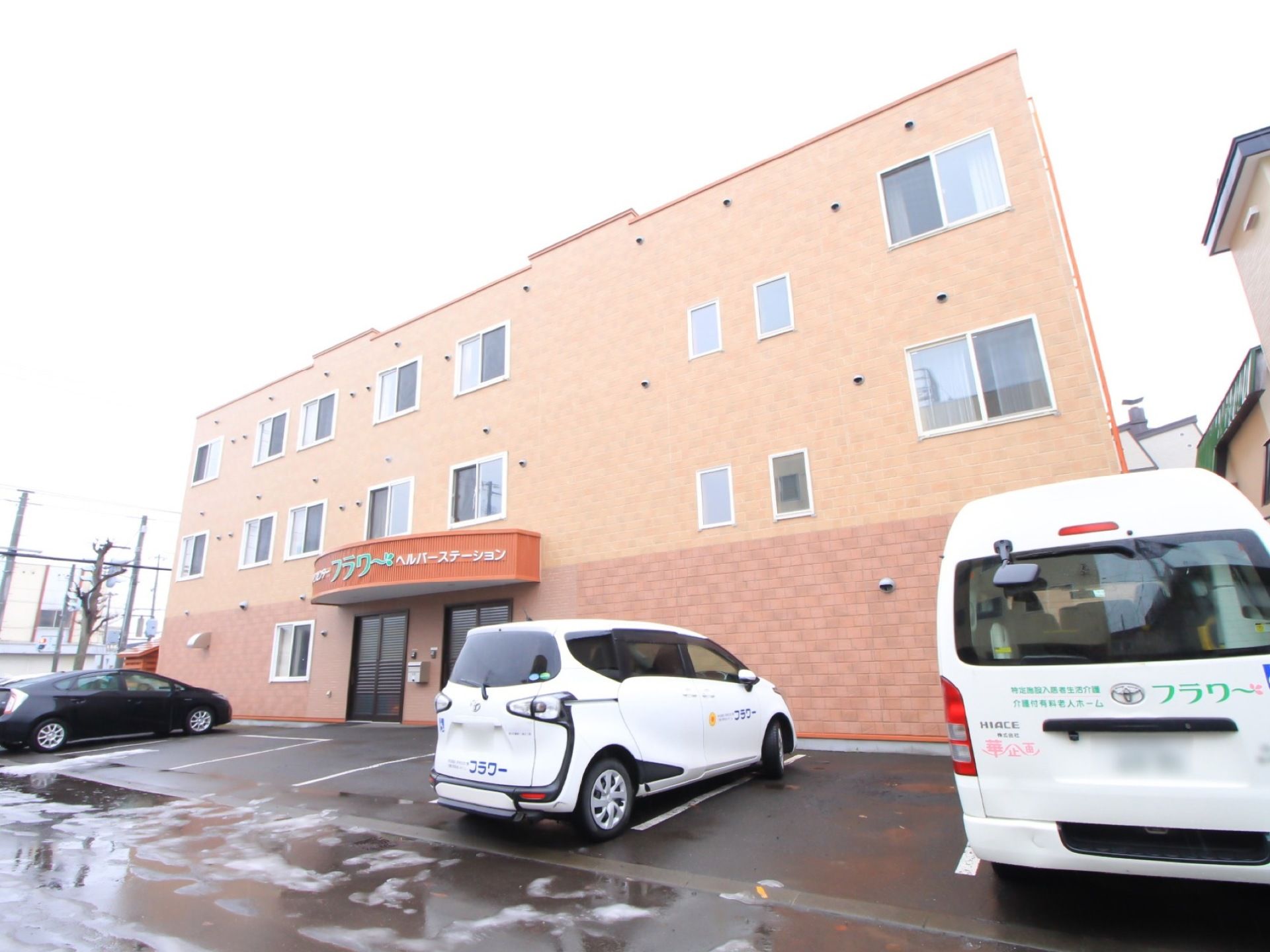 施設は３階建ての建造物で駐車場が完備されている。大きさの異なる施設車が２台ある。日当たりに恵まれている。