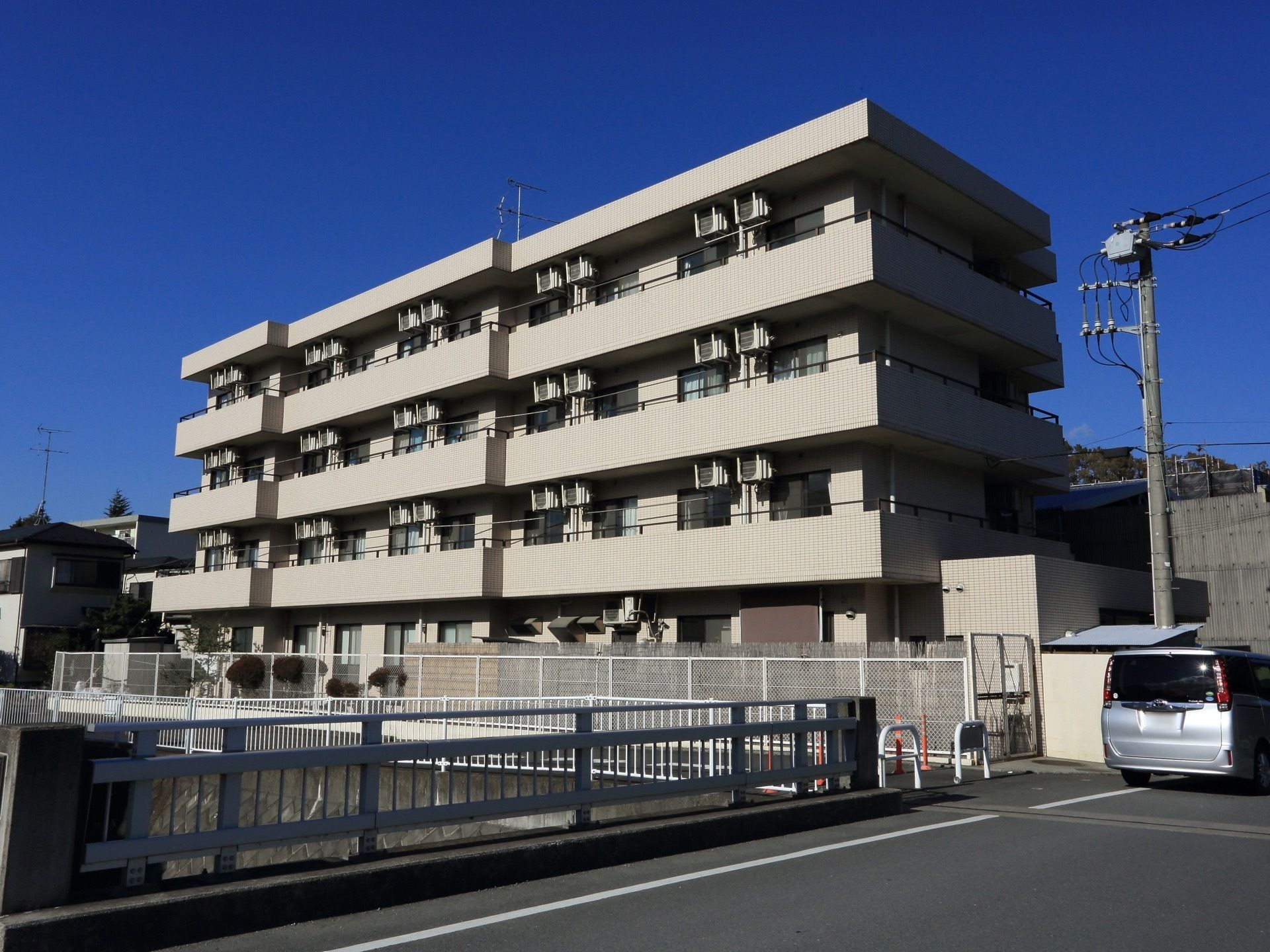 川沿いに建てられた４階建ての集合住宅のような落ち着いた外観。日当たりが良く、各居室がベランダに面している。