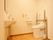 洗浄ホースがついた洋式トイレがある。トイレの前に洗面台があり、アルコール消毒とポンプ式の手洗い石鹸が置いてある。