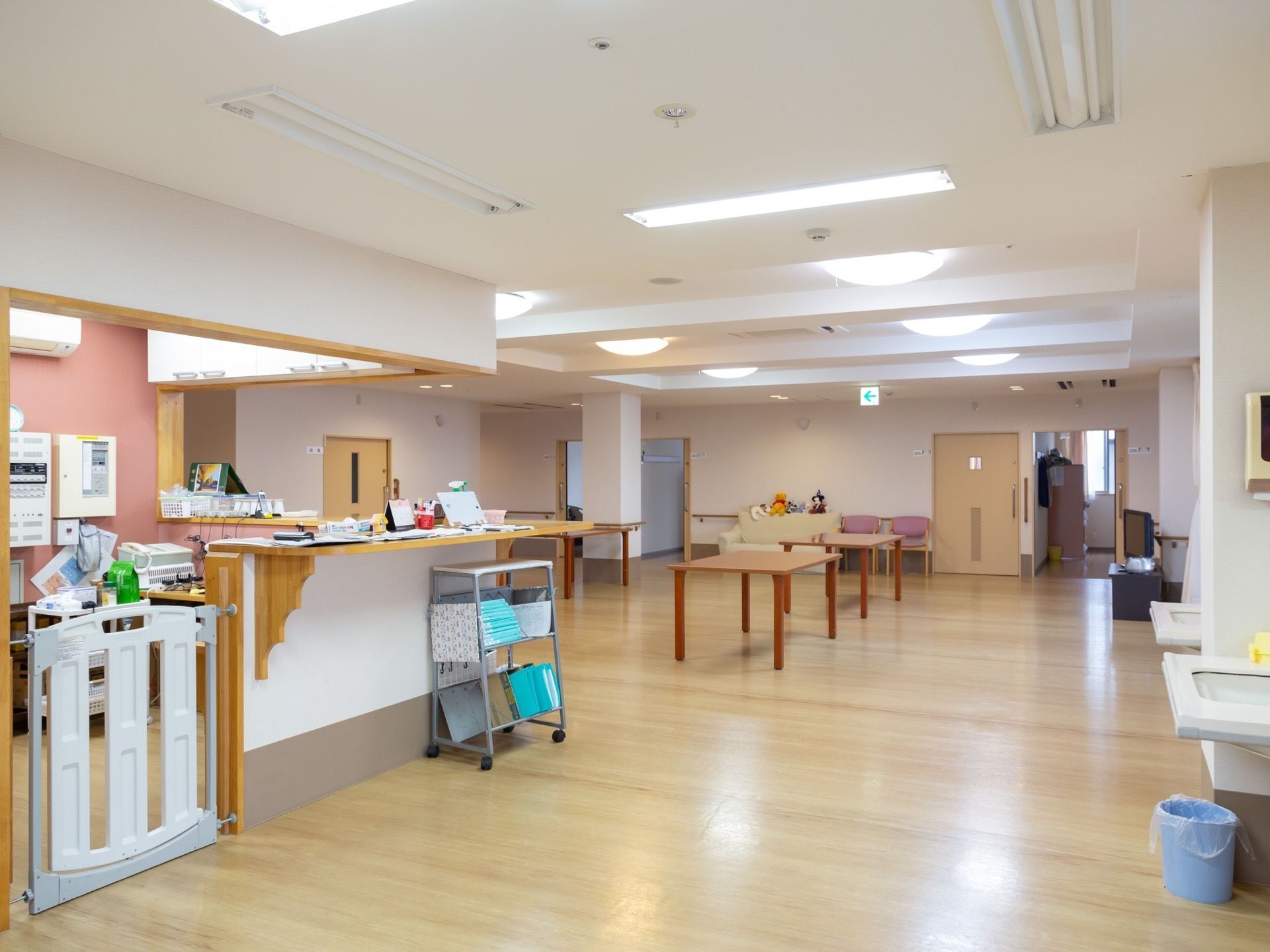 左側にスタッフの事務所があり、カウンターになっている。右側には洗面台が設置され、奥にテーブルが並べられている。