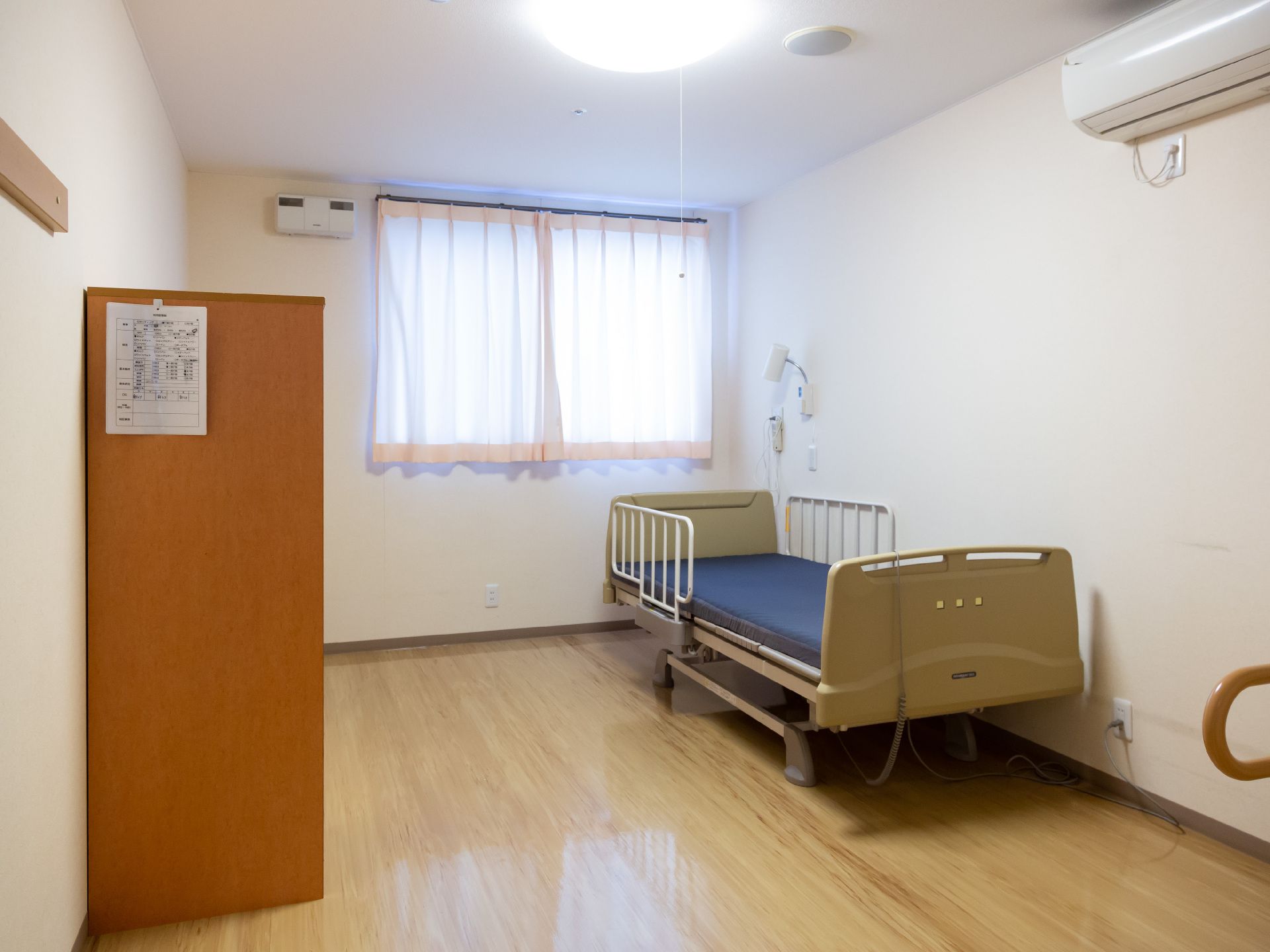 転落防止柵があるベッドが設置された、明るく清潔感のある居室