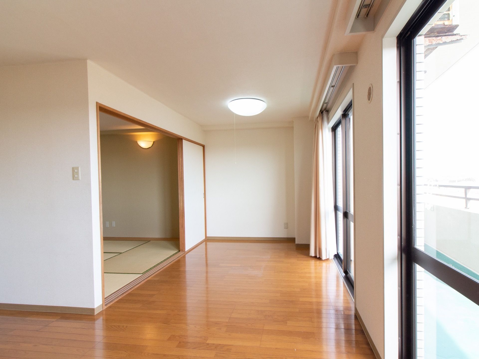 フローリングの部屋の他に和室が設けられており、間には段差がない。大きな窓からはたっぷり外光が降り注ぐ。