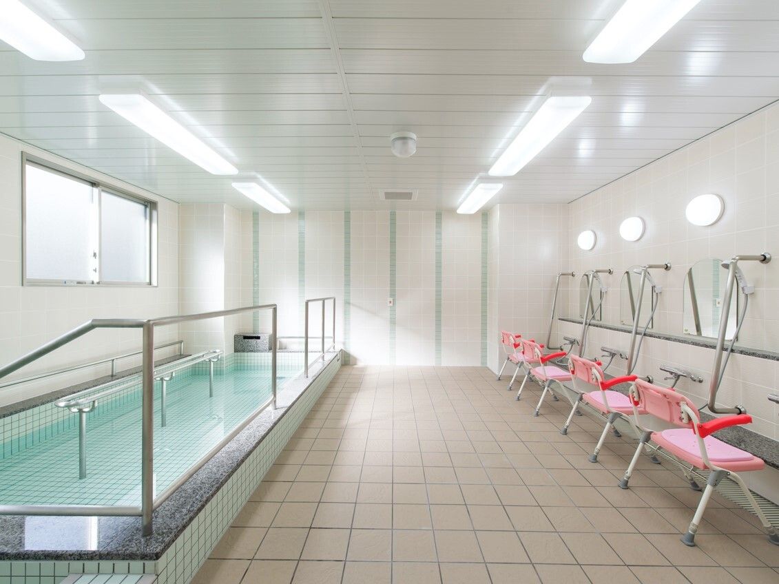 手すりが付いた大きな浴槽にはたっぷりのお湯が張られている。右側にはシャワースペースもある。