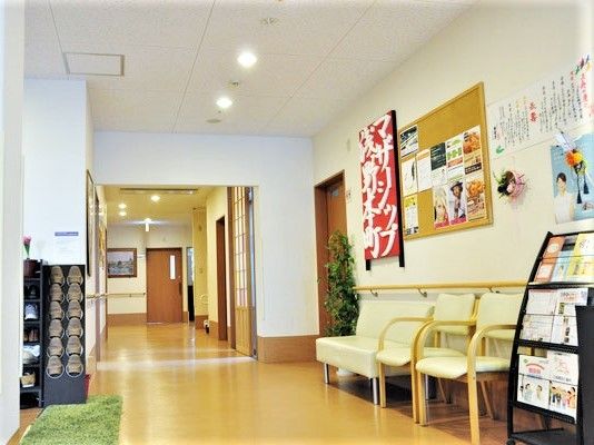 明るい雰囲気のロビーには黄色の椅子やマガジンラック、スリッパラックが置かれている。