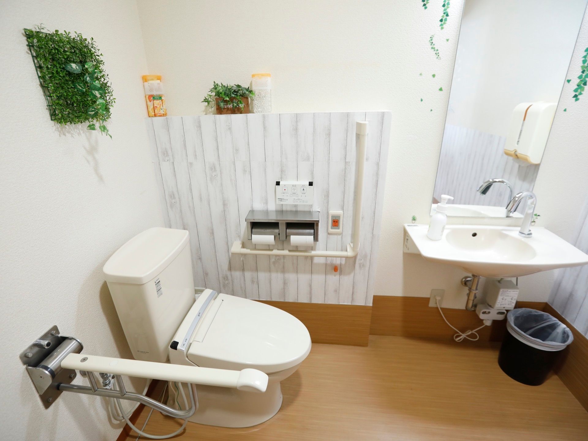 トイレは白い内装で、明るく清潔感がある。個室内には植物を模したフォールステッカーが貼られ、人工観葉植物なども飾られている。