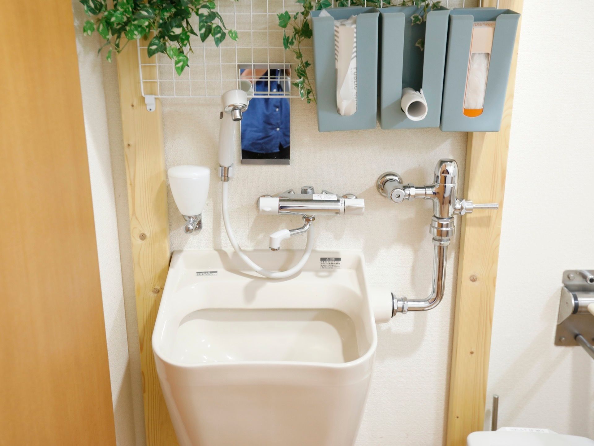 トイレの中には、汚物流しも併設されている。流しの上に棚を設置して、手袋やティッシュなどの備品が取りやすく収納されている。