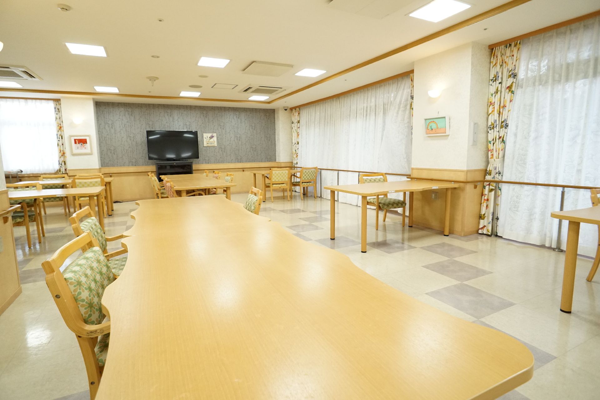 囲むようにテーブルが置かれ、椅子が多く設置された共有スペース