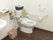 壁にL字型手すりや可動式手すりが設置されたトイレである。スペースが広く確保でき、スムーズな移動ができる。