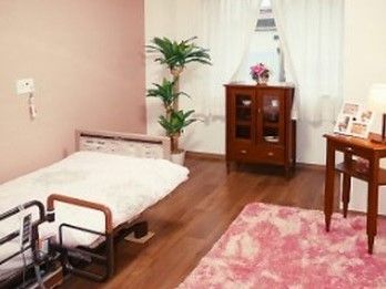 フローリングのシンプルな居室にはカーテンや家具、ベッドが付いている。
