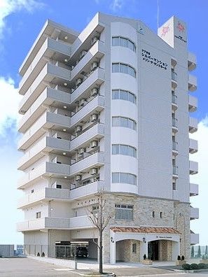 鉄骨造の背の高い建物の様子。青空が広がっている。美しい外観写真