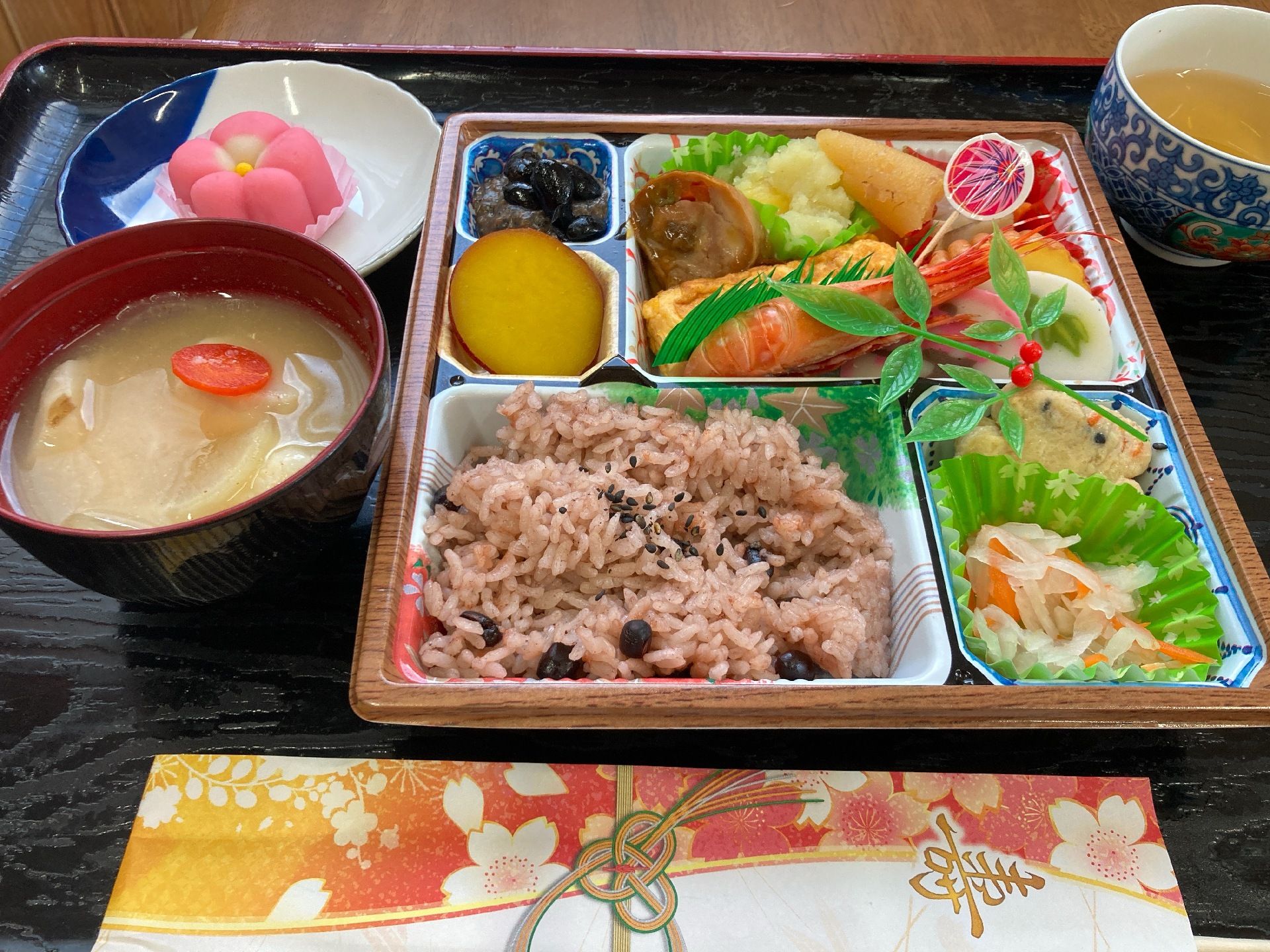 刺身の盛り合わせと赤飯と苺のデザートが付いたメニュー