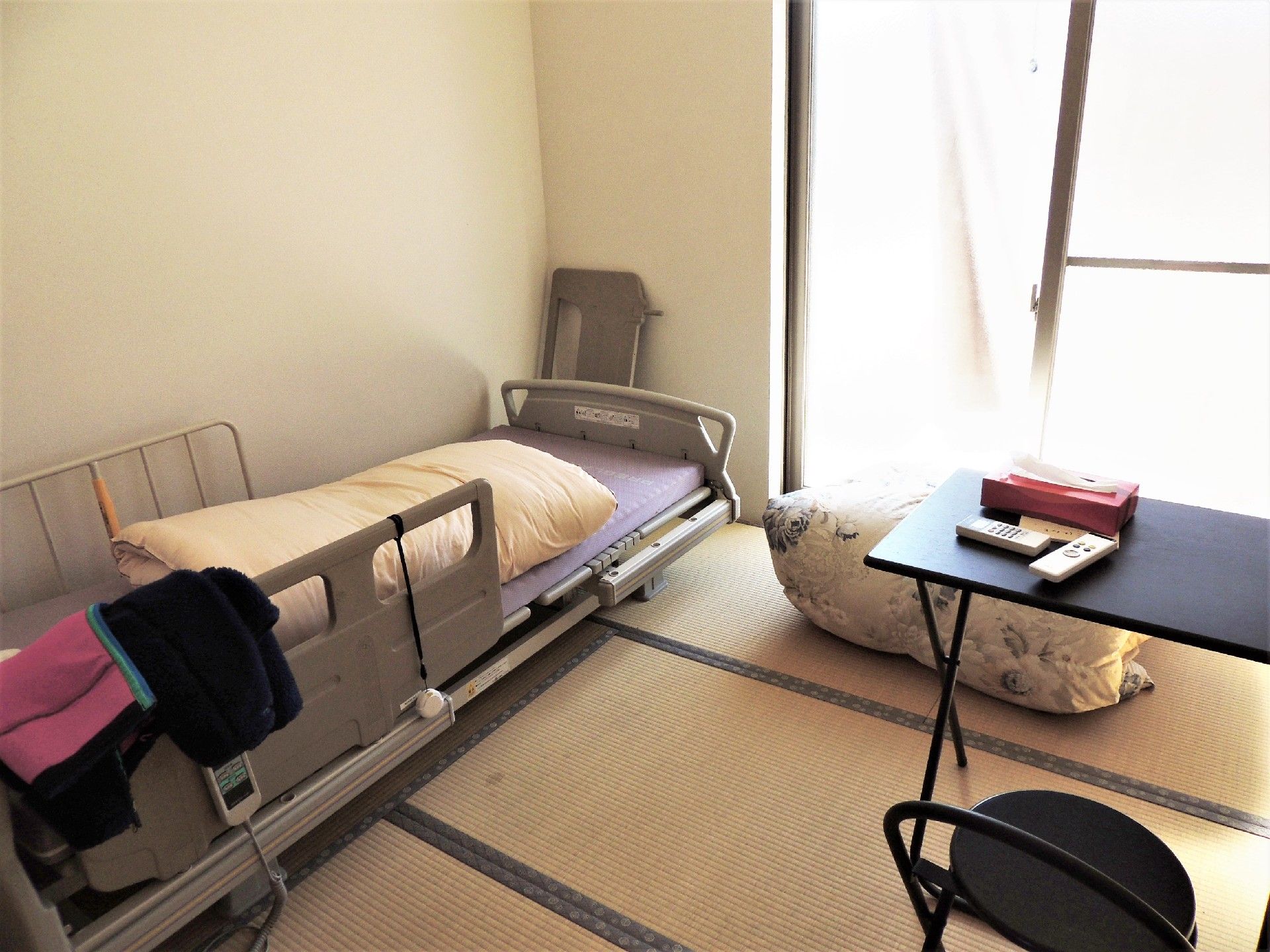 左側にベッド、右側に調度品が並べられている施設内の二人部屋の様子