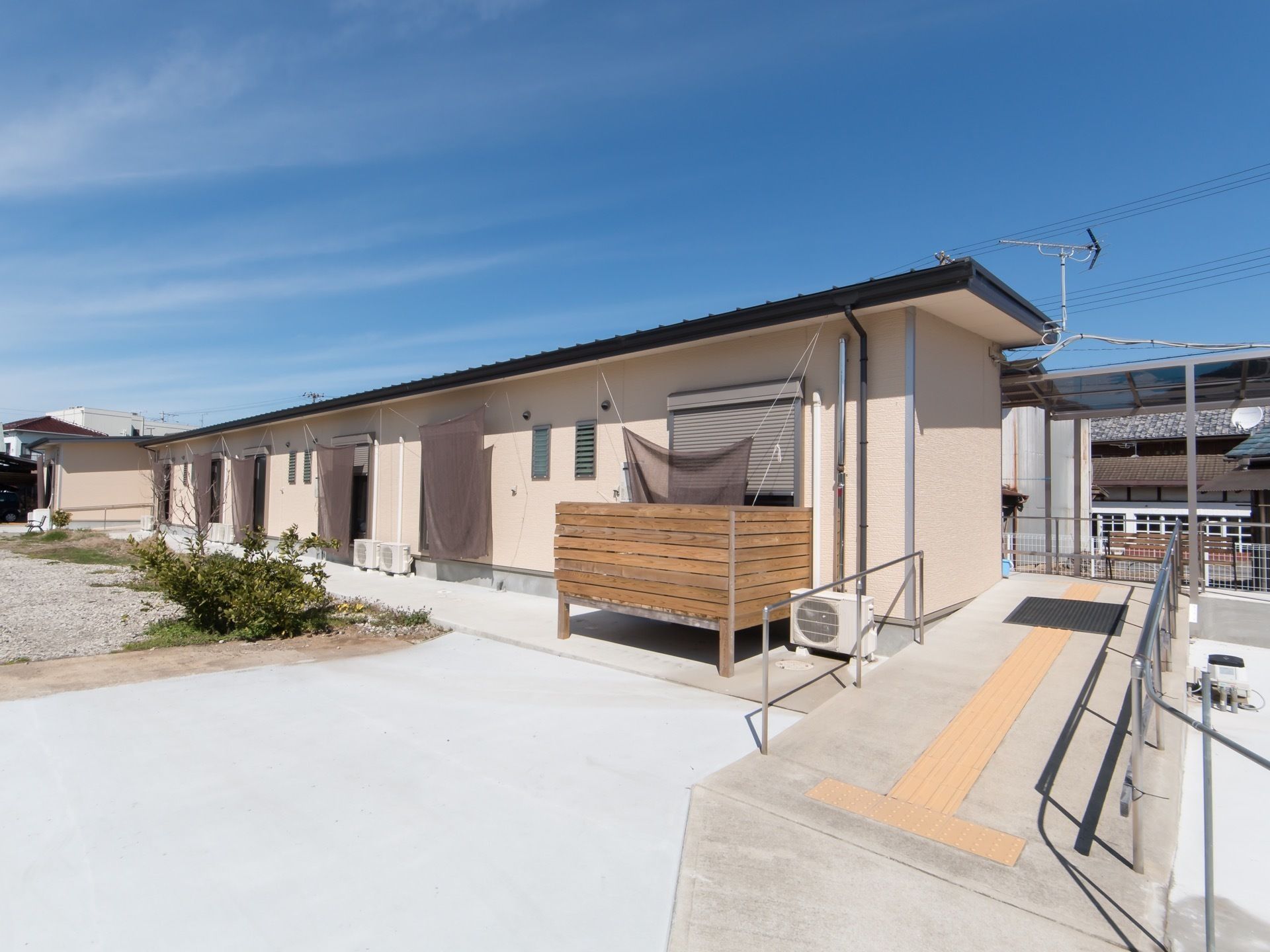 施設は平屋建てになっていて、建物の右側には点字ブロックが設置されたスロープがある。すべての窓に日よけのシェードが付けられている。