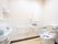 白色の洋式便座が備え付けられたトイレである。背もたれクッション、手すりのほか緊急呼び出しボタンも設置されている。