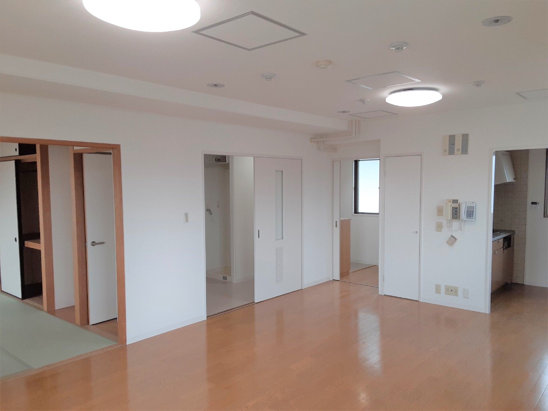 広々とした部屋はワンルームタイプではなく複数の部屋があり、本格的な和室も用意されている。家具や家電は置かれていないが、奥にはキッチンも見える。
