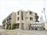 ３階建て構造の施設外観。レンガ風の外壁には施設名の看板が直接取りつけてあり、また雨どいとなるパイプが上下に伸びている。