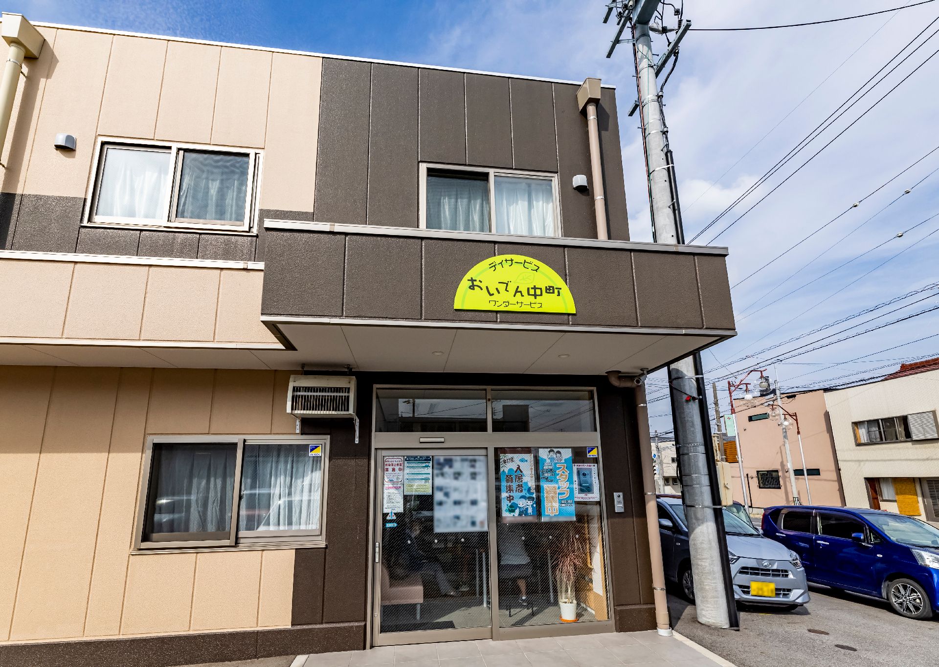 2階建てで、茶色の落ち着いた色合いが特徴の施設の外観