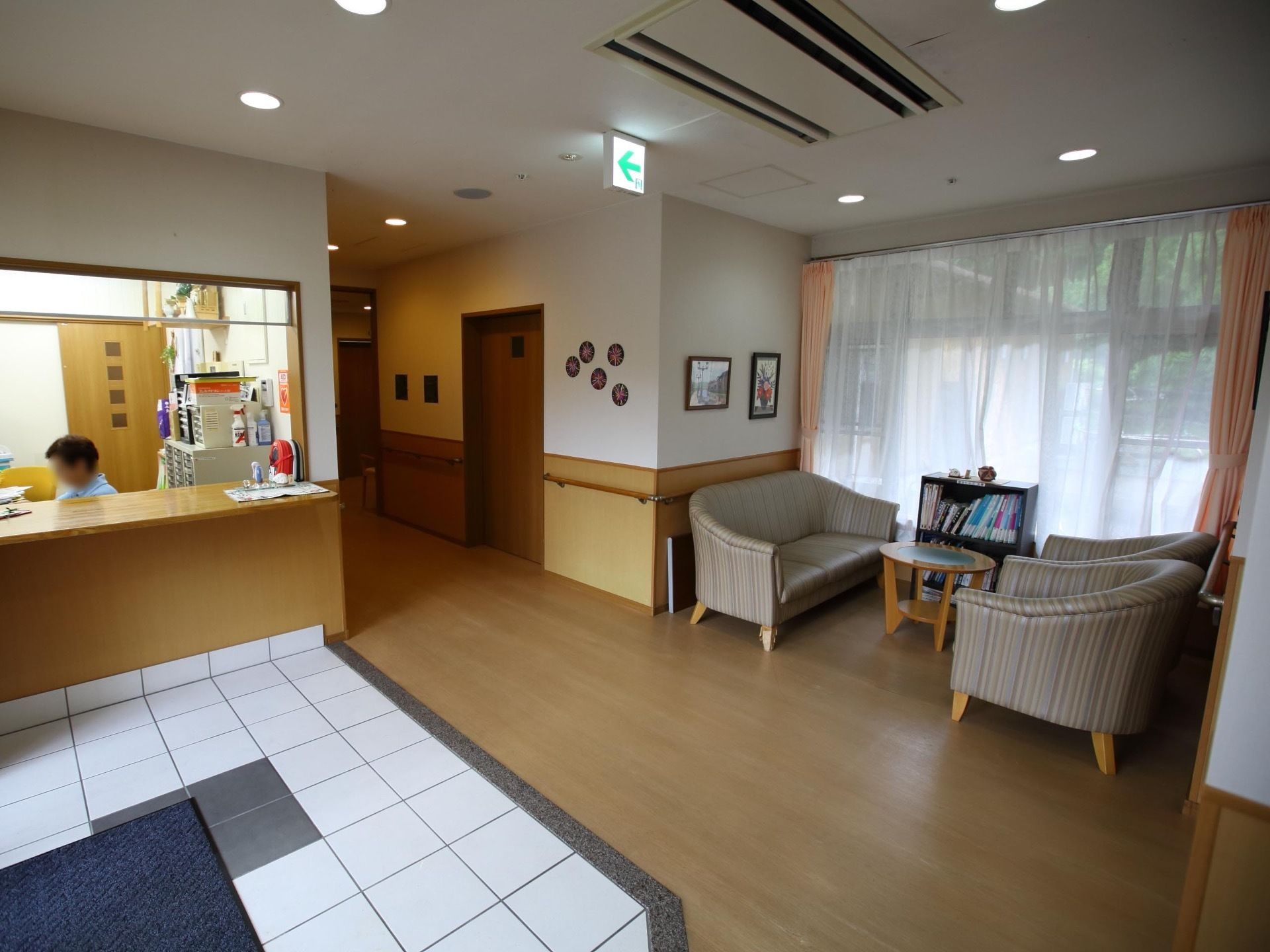 玄関を入ると受付が設置せれており、職員が駐在している。玄関にはマットが敷かれている。通路はフローリングである。