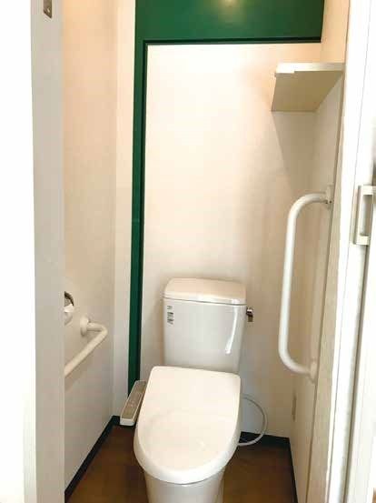 引き戸を開けると手すりが付いたトイレがある。白を基調とした清潔感あふれるスペース。