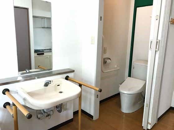 洗面所には両サイドに手すり、正面に鏡が設置されている。すぐ横にはトイレがある。
