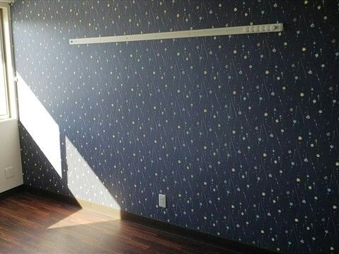 紺の壁紙には星空のような模様が描かれ、フローリングの部屋には窓があり、日当たりも良好。家具はない。