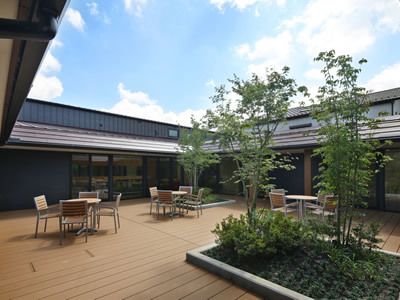 建物の中央に設置された広いウッドデッキには緑のスペースも多く、青い空を眺めることができる。