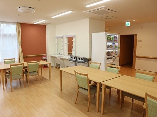 ダイニングテーブルが並んだ食堂は、落ち着いた雰囲気。自動販売機やごみ箱もある。