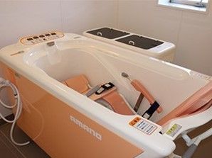 介護度の高い方のために機械浴槽が設置された浴室。窓が付き、明るい雰囲気。