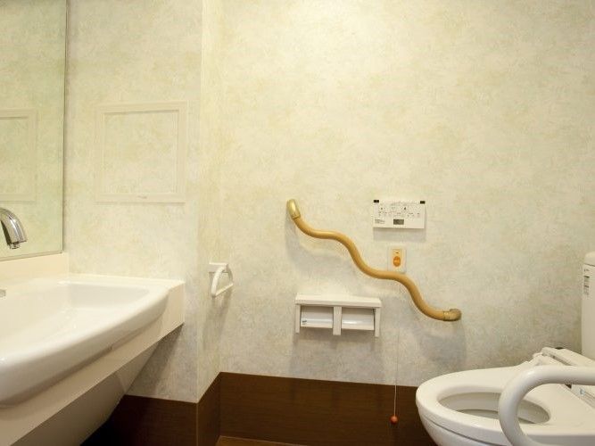 トイレには波型の手すりと呼び出しボタン、洗面所が付いている。
