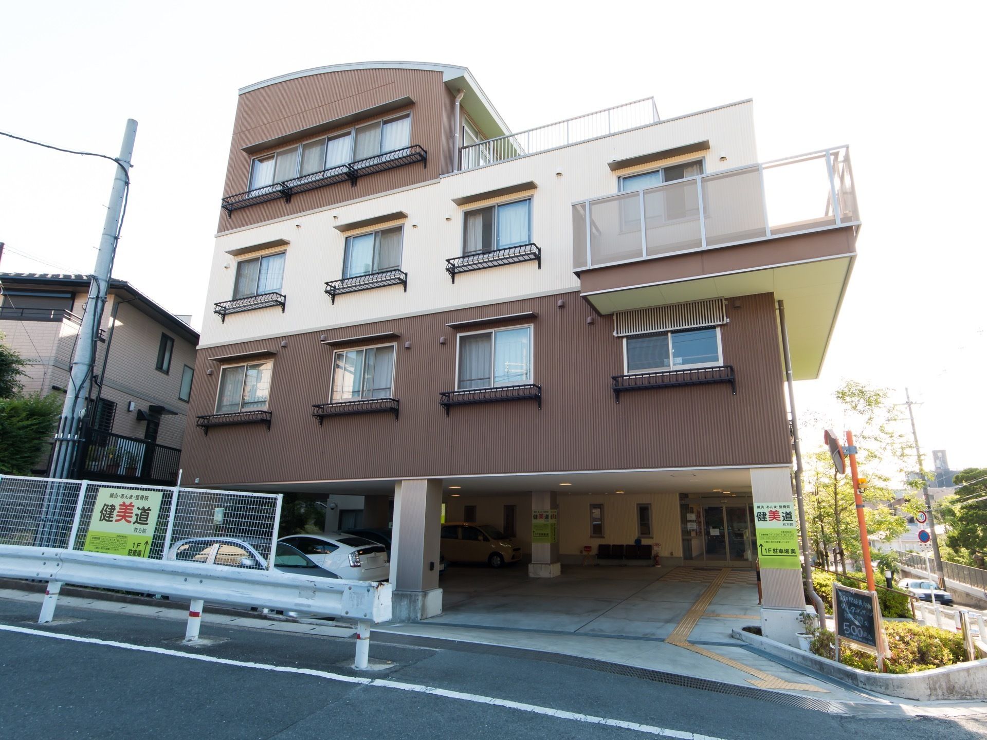 白色と茶色のツートンカラーの外壁を持つ、一部４階建ての施設である。玄関前のスペースは駐車場になっている。