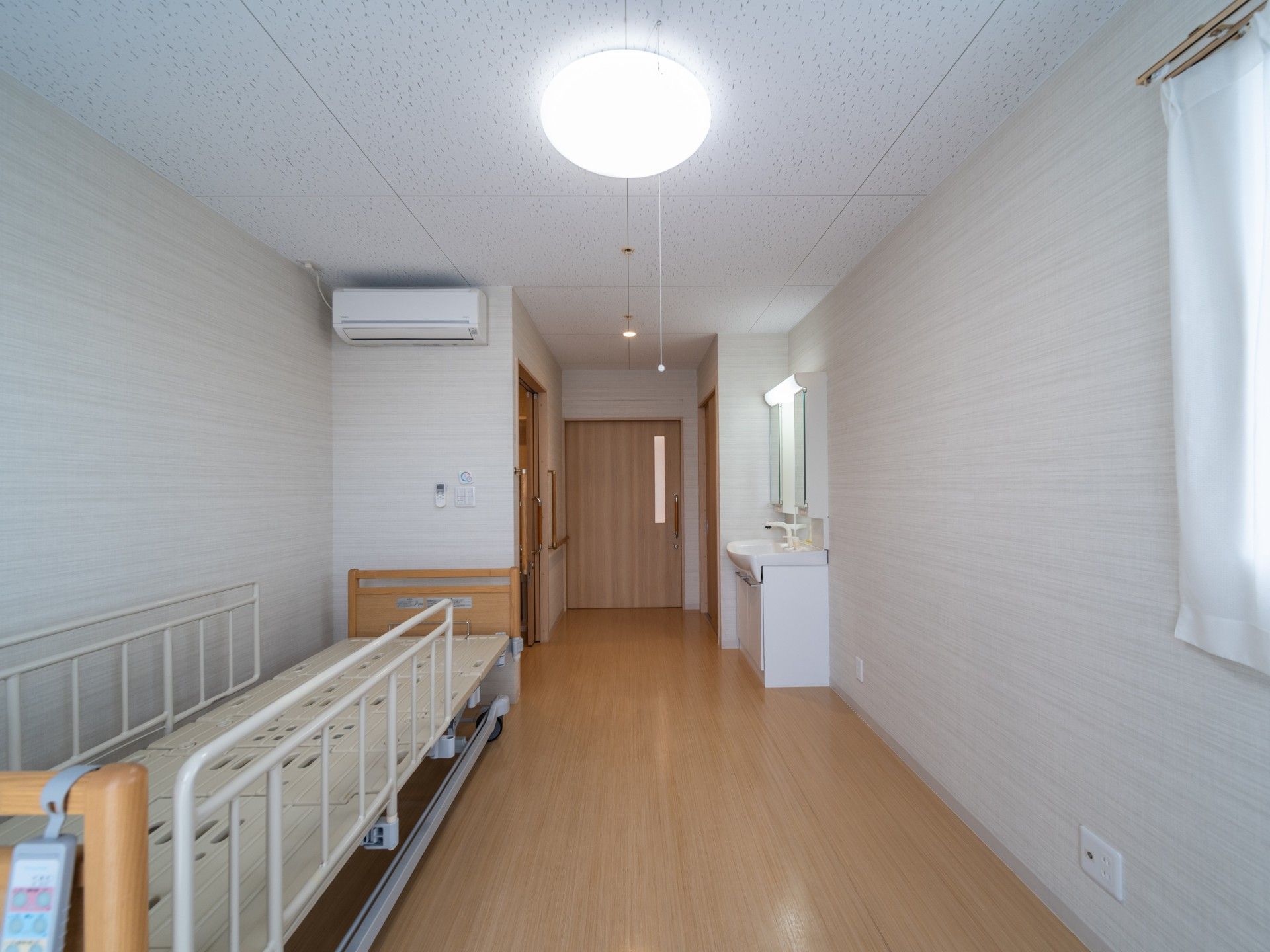 介護用ベッドとトイレ、洗面所が設置されている個室