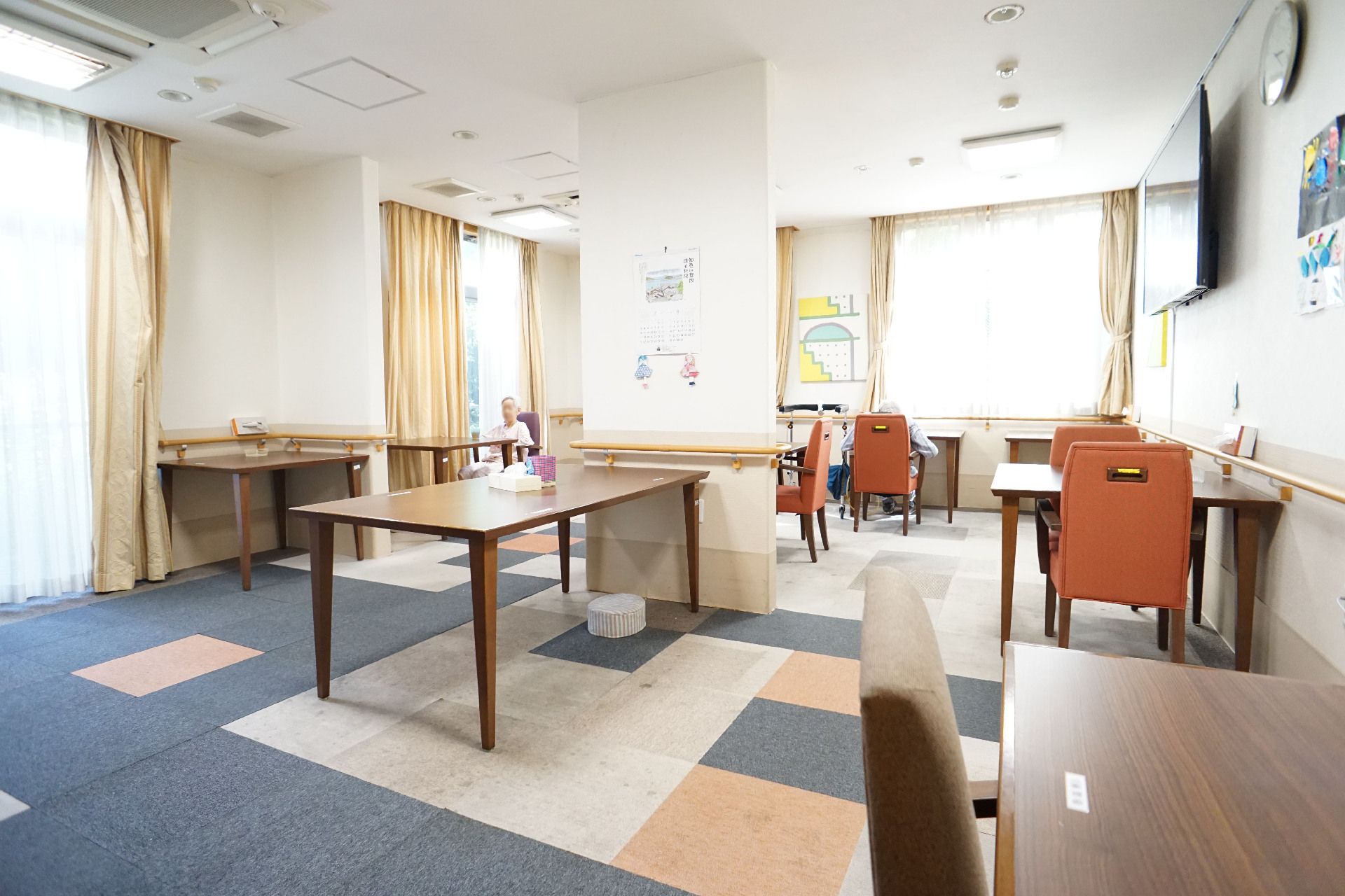 窓ガラスに囲まれた木製の椅子が置いてある広間