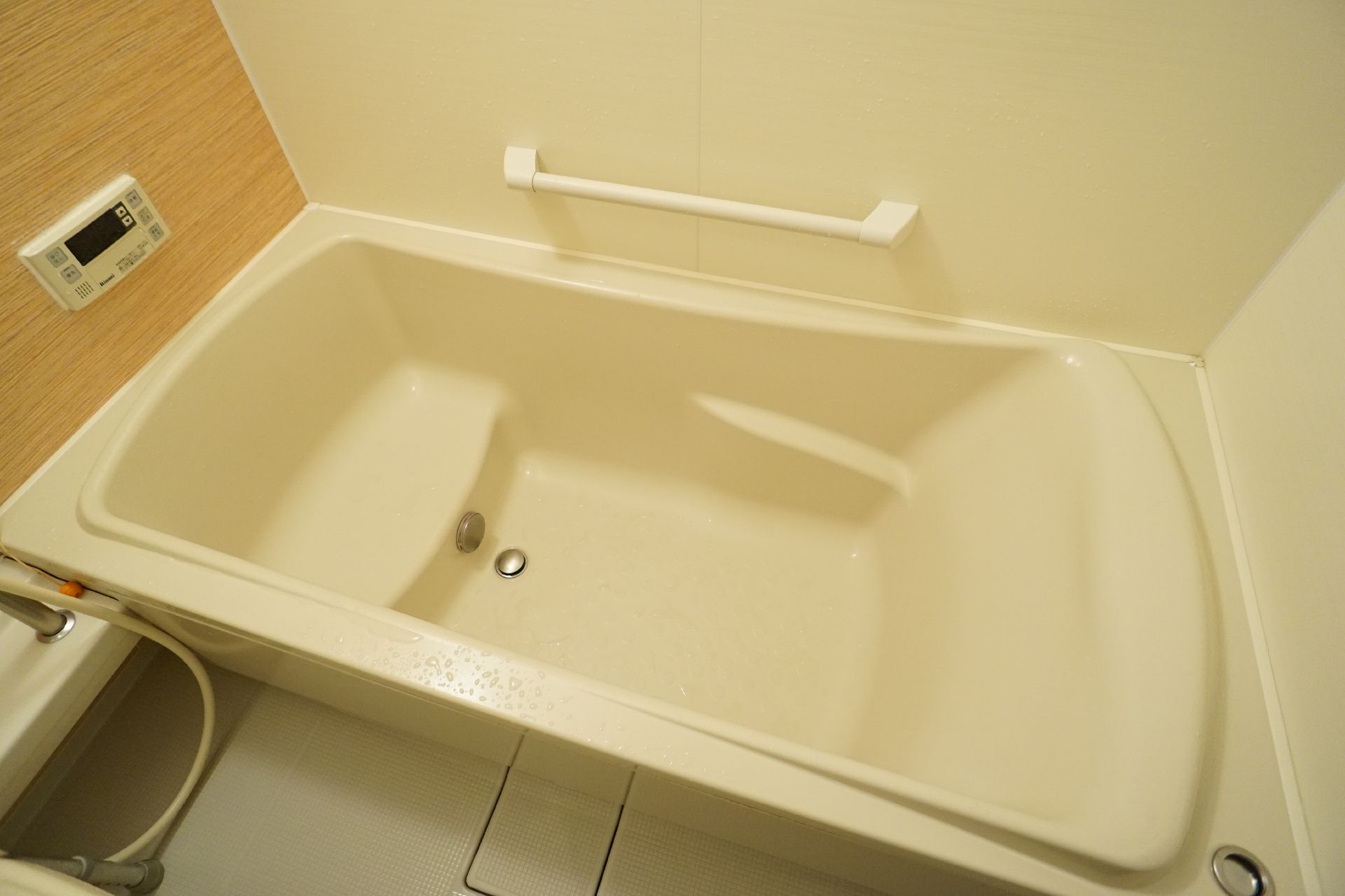 白い壁の部屋に配置された白い浴槽